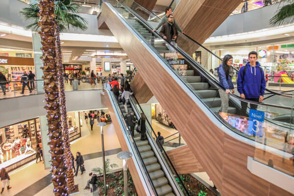 Centro comercial en Santiago con escaleras mecánicas concurridas.